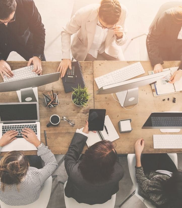 A team collaborating on laptops at a shared desk